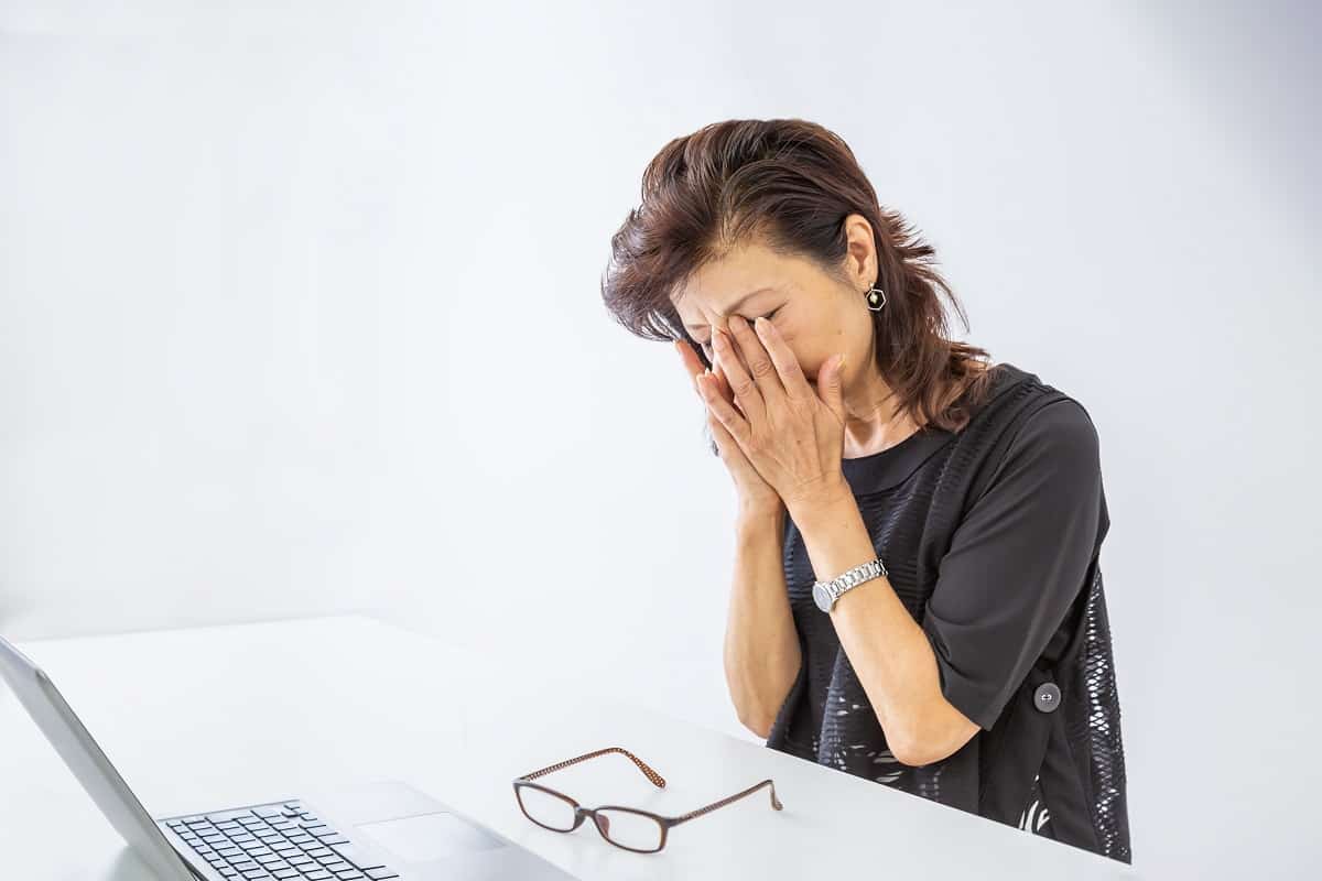 une femme fatiguée devant un ordinateur